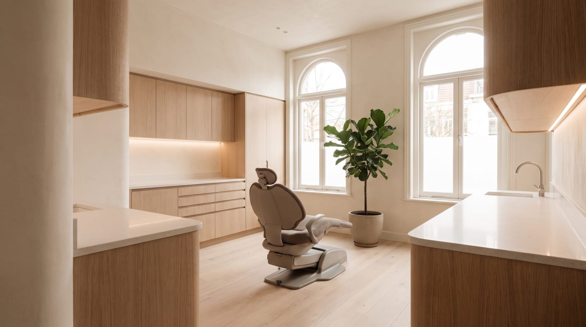 A treatment room at Unique Perfect Smile TT: pale wood, arched windows and daylight